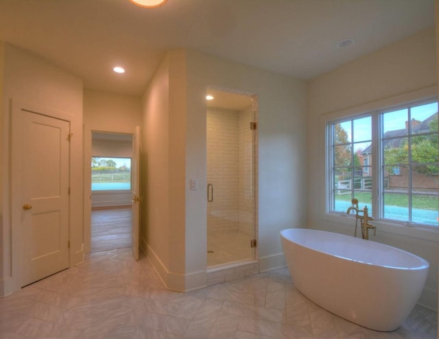 bathroom featuring shower with separate bathtub