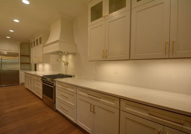 kitchen featuring white cabinetry, high quality appliances, tasteful backsplash, dark hardwood / wood-style flooring, and custom exhaust hood