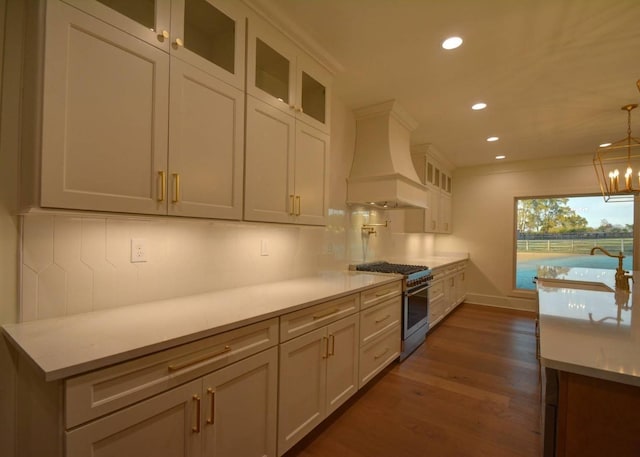 kitchen with premium range hood, dark hardwood / wood-style floors, white cabinets, and high end stove