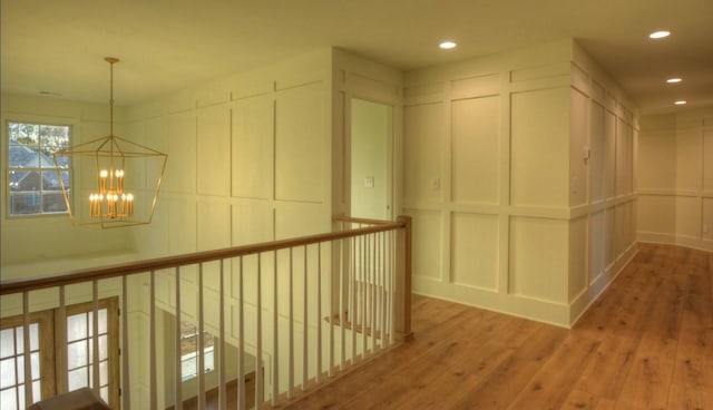 corridor featuring wood-type flooring and a chandelier