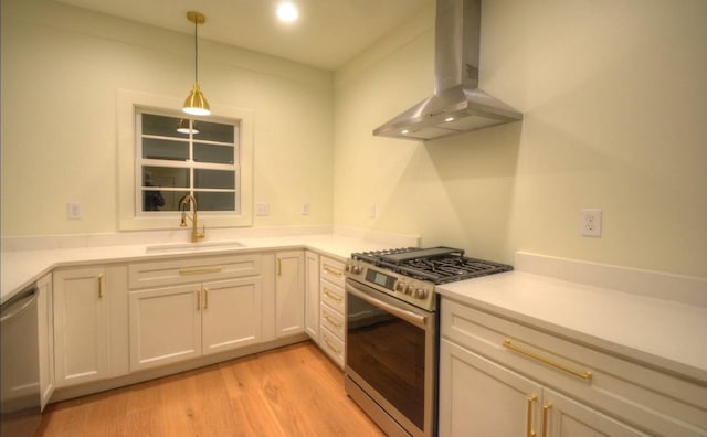 kitchen featuring pendant lighting, sink, light hardwood / wood-style flooring, appliances with stainless steel finishes, and island range hood