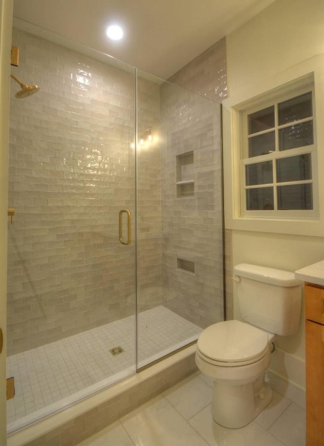 bathroom with an enclosed shower, vanity, tile patterned floors, and toilet