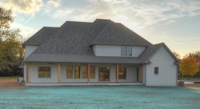 rear view of house featuring a yard and central AC