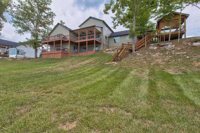 rear view of house featuring stairway, a yard, and a wooden deck