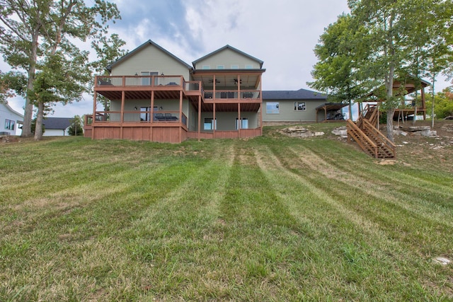 rear view of property featuring stairway, a wooden deck, and a yard