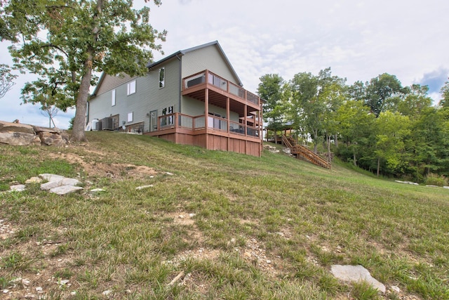 back of house featuring a yard, central AC, and stairs