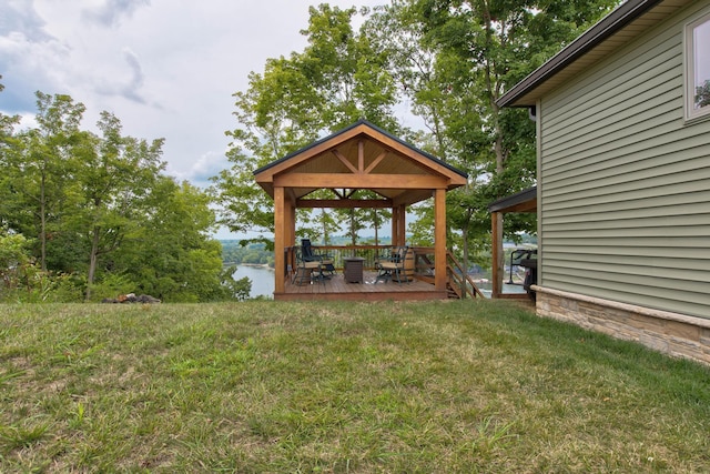 view of yard with a gazebo and a deck with water view