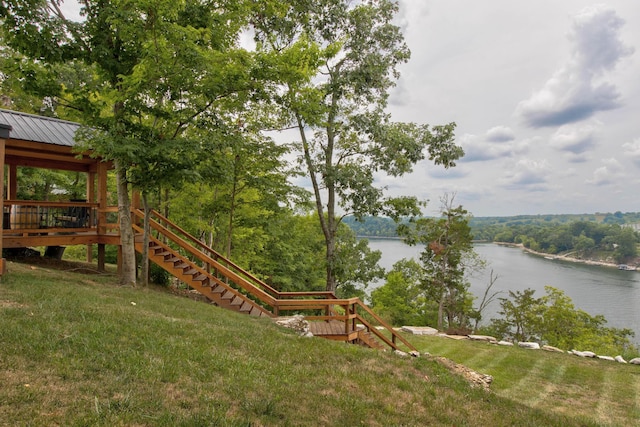 view of yard featuring a water view and stairs