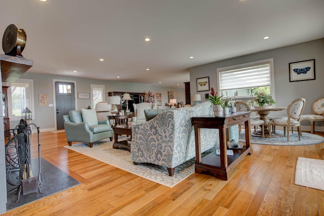 living area with recessed lighting, light wood-type flooring, and baseboards