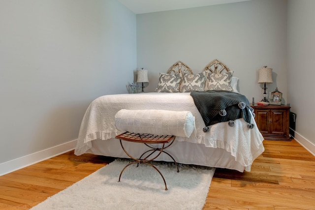 bedroom with baseboards and wood finished floors