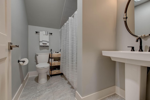 full bathroom featuring a shower with shower curtain, baseboards, and toilet