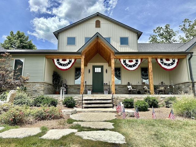 view of front of house with board and batten siding, a porch, and stone siding