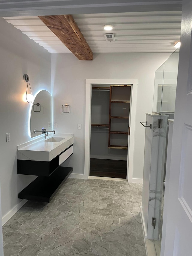 bathroom featuring vanity, beam ceiling, and a shower with shower door