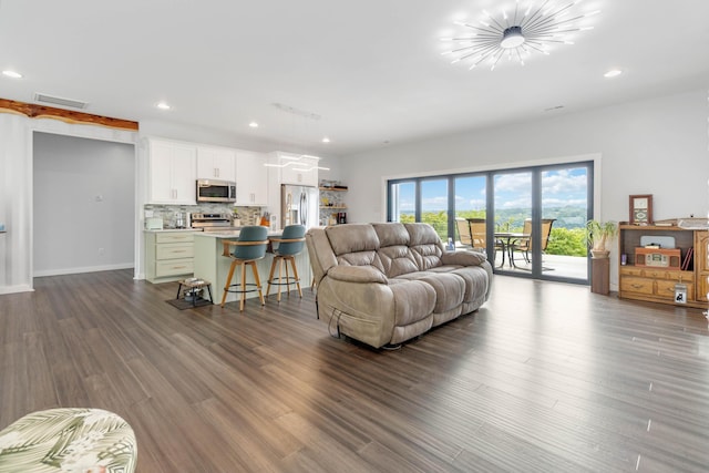 living room with dark wood-type flooring and a notable chandelier