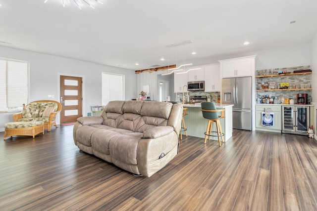 living room featuring bar area, wine cooler, and dark hardwood / wood-style flooring