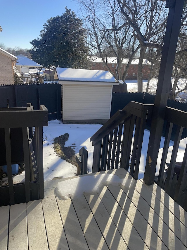 snow covered deck featuring a storage unit