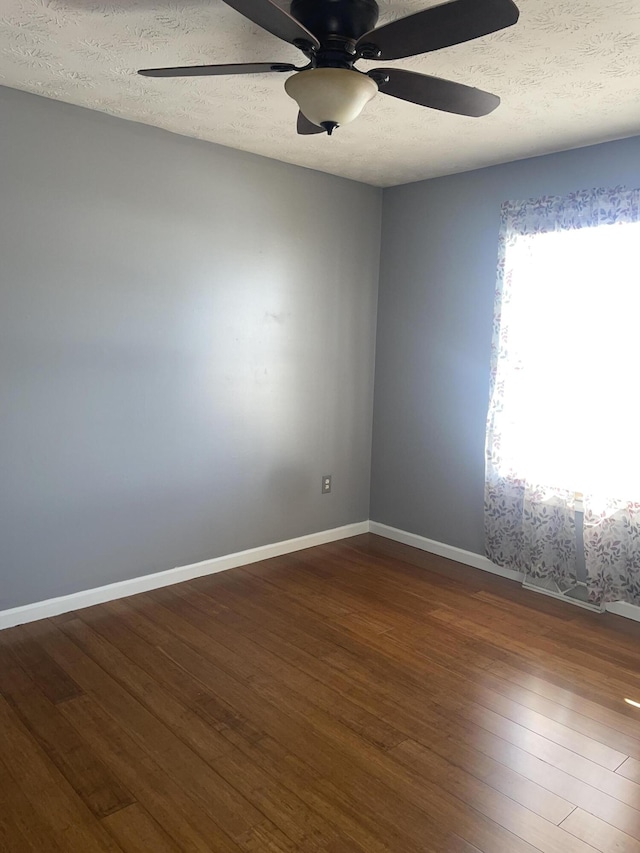 empty room featuring ceiling fan, hardwood / wood-style floors, and a textured ceiling