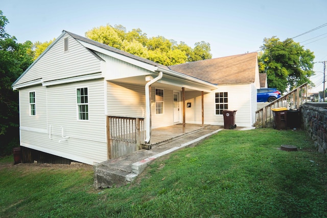 rear view of property featuring a yard