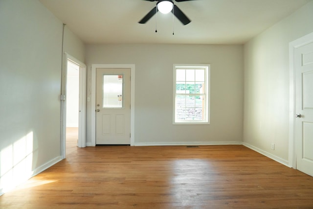 foyer entrance with ceiling fan and light wood-type flooring