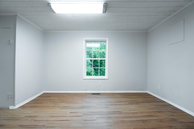 spare room with crown molding and light hardwood / wood-style flooring