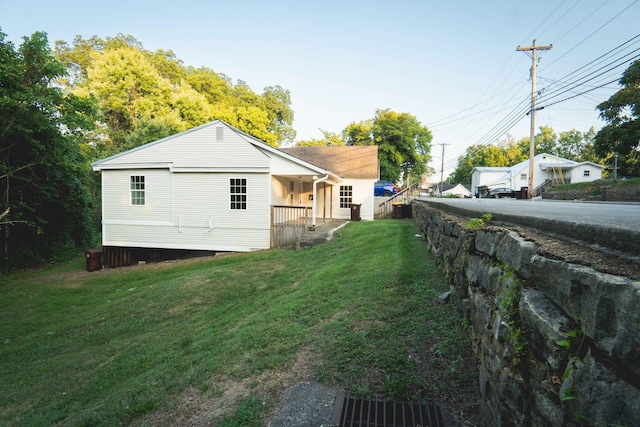 view of side of property with a porch and a yard