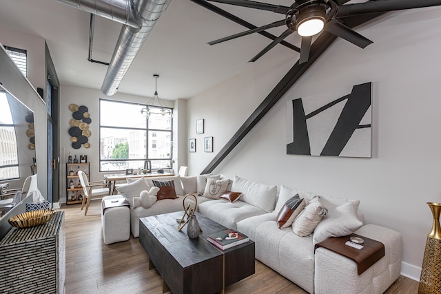 living area featuring baseboards, ceiling fan, and wood finished floors