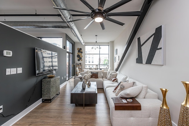 living area featuring baseboards, ceiling fan, and wood finished floors