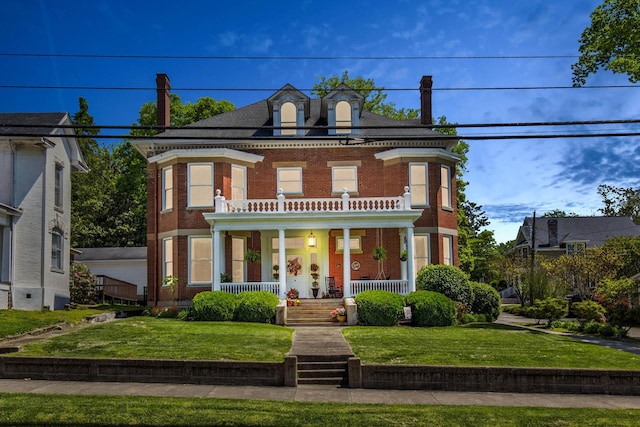 view of front of house with a porch, brick siding, a balcony, and a front lawn