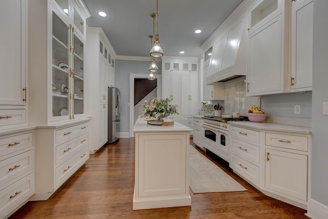 kitchen featuring glass insert cabinets, a center island, double oven range, and light countertops