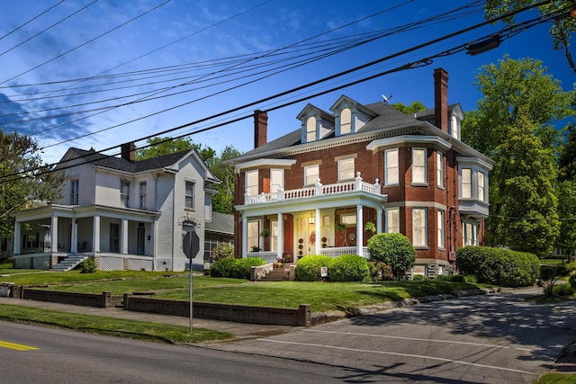 victorian house featuring a front lawn and covered porch