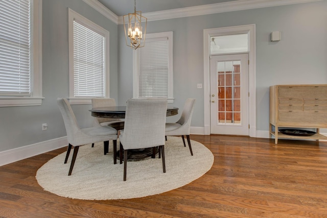 dining room featuring dark wood-style floors, baseboards, crown molding, and an inviting chandelier