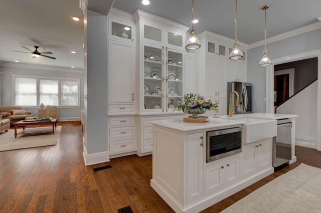 kitchen featuring appliances with stainless steel finishes, glass insert cabinets, and white cabinets