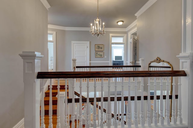 corridor with baseboards, ornamental molding, and a notable chandelier