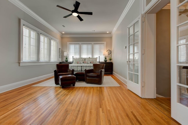 sitting room with light wood-style floors, baseboards, and crown molding