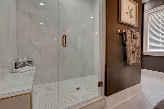 full bathroom featuring tile patterned flooring, baseboards, and a marble finish shower