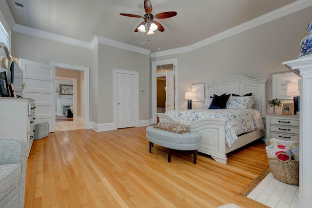 bedroom featuring ornamental molding, light wood-type flooring, and ceiling fan