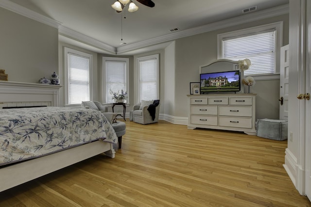 bedroom with visible vents, crown molding, and light wood finished floors