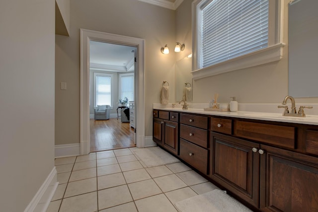 full bathroom featuring double vanity, ornamental molding, a sink, tile patterned flooring, and baseboards