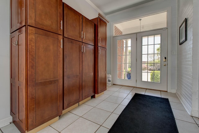 doorway with a healthy amount of sunlight, crown molding, and light tile patterned floors