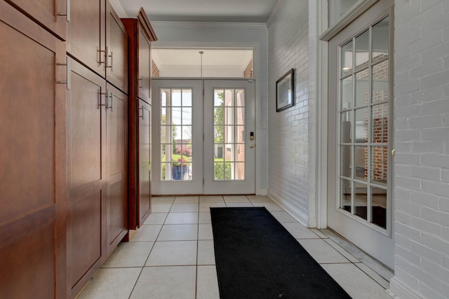 doorway featuring light tile patterned floors, brick wall, and crown molding