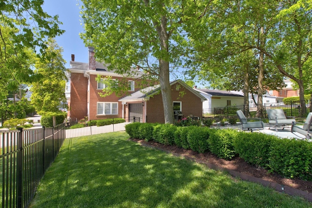 exterior space featuring a garage, a fenced backyard, and a patio