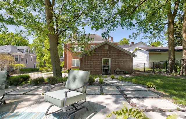 back of property featuring a patio area, fence, and brick siding