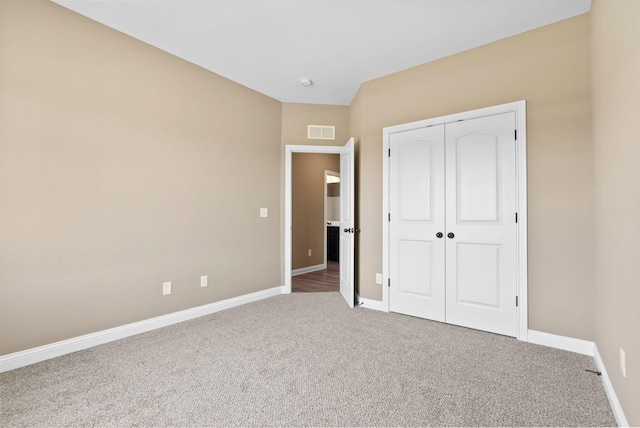 unfurnished bedroom featuring carpet flooring and a closet