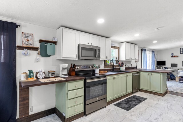 kitchen featuring white cabinetry, green cabinets, sink, appliances with stainless steel finishes, and light tile patterned floors