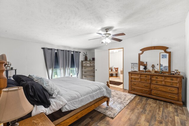 bedroom with a textured ceiling, ceiling fan, and dark wood-type flooring