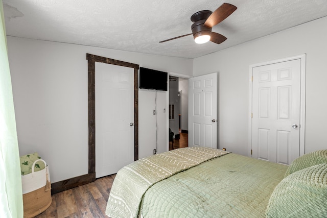 bedroom featuring a textured ceiling, wood-type flooring, and ceiling fan