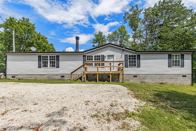 rear view of property featuring a yard and a wooden deck