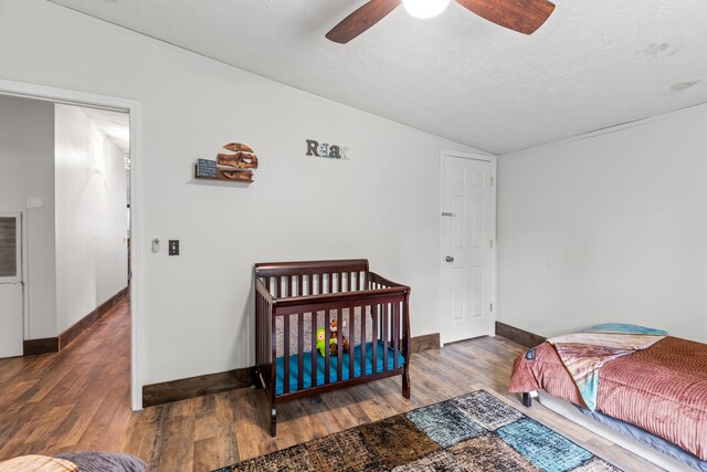 bedroom featuring a textured ceiling, ceiling fan, hardwood / wood-style flooring, and vaulted ceiling