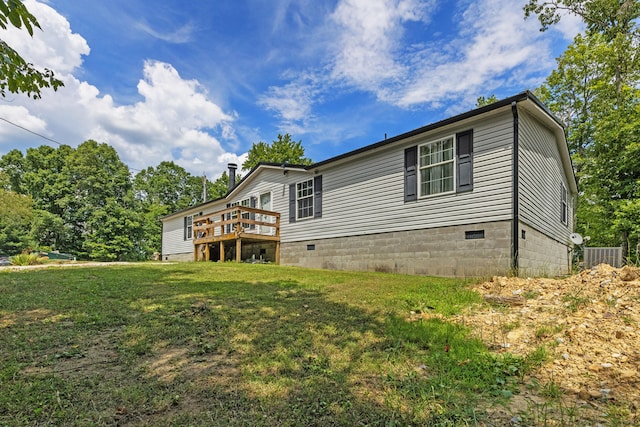 view of side of home with a deck and a lawn