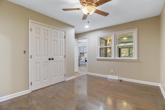 unfurnished bedroom featuring a closet, ceiling fan, and dark hardwood / wood-style floors